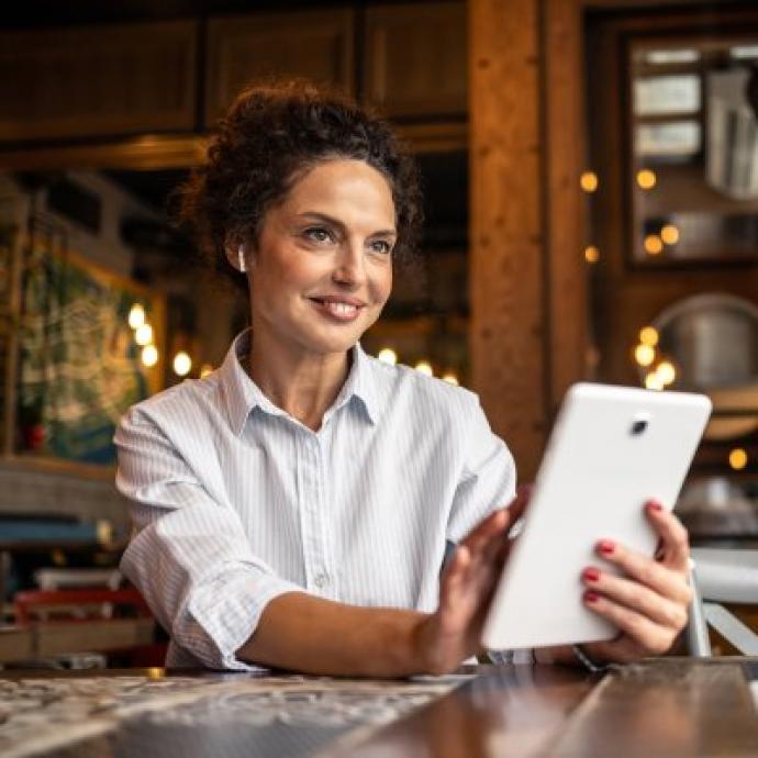 Vrouw met tablet aan tafel